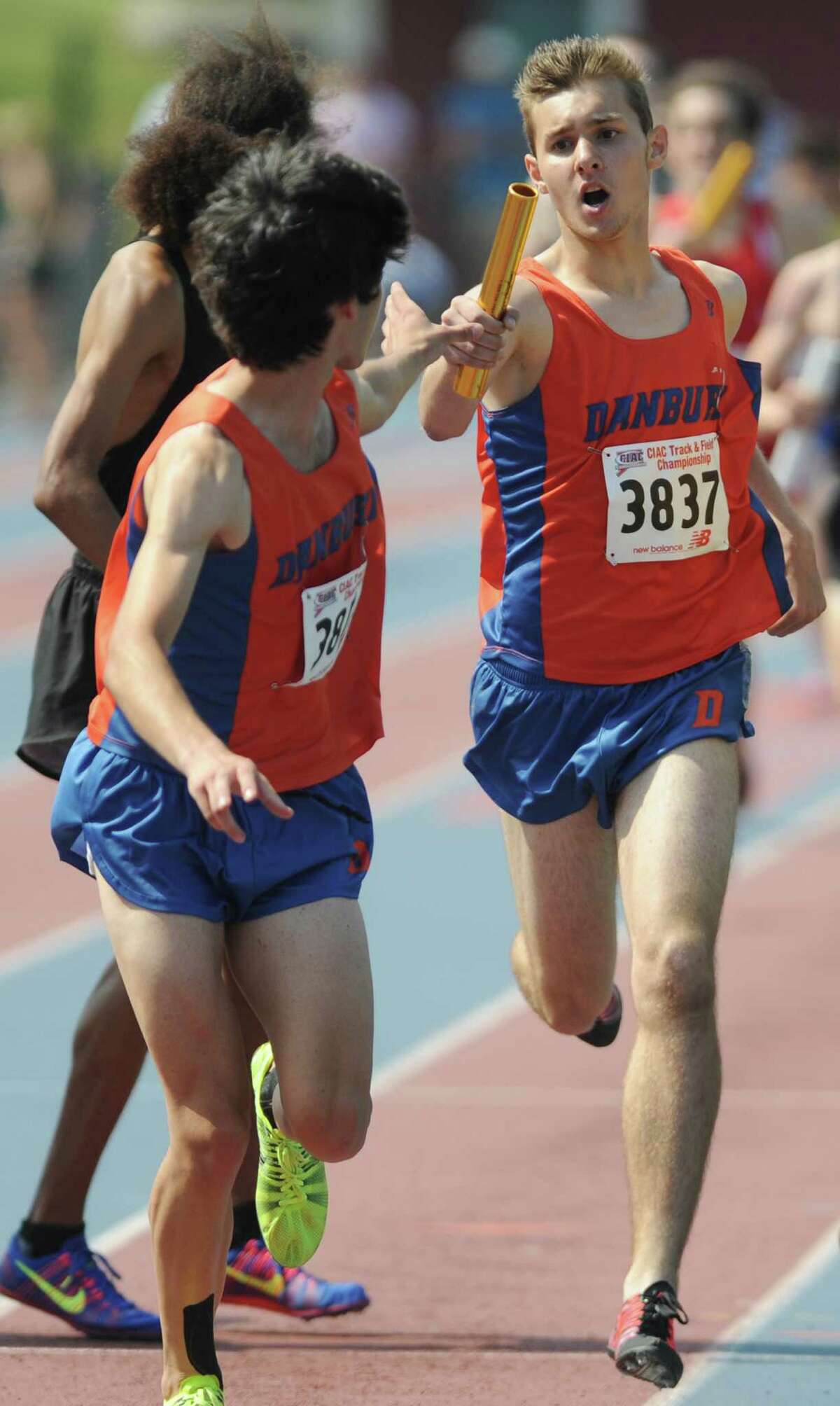 Danbury's Jake Roberts hands the baton off to Steven Farkas in the boys 4x800 meter relay at the CIAC Class LL Connecticut Outdoor Track & Field State Championship at Danbury High School in Danbury, Conn. Tuesday, June 3, 2014. Danbury won the 4x800 meter relay with a time of 8:08.25.