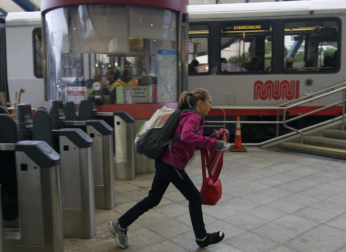 A passenger runs to catch an inbound Metro lightrail streetcar at the West Portal station on the third day of a sickout by Muni employees in San Francisco, Calif. on Wednesday, June 4, 2014. More workers reported for work today, but the system is still not operating at full capacity. The union employees are upset by a contract proposal made by MTA management.