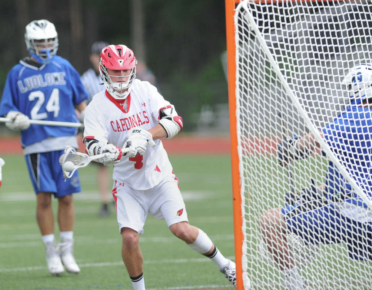 At left, Sam Saleeby (#4) of Greenwich shoots and scores past Fairfield Ludlowe goalie John Carey during the state playoff lacrosse match between Greenwich High School and Fairfield Ludlowe High School at Greenwich, Wednesday, June 4, 2014. At left is Fairfield Ludlowe defender Bryan Pacewicz (#24).