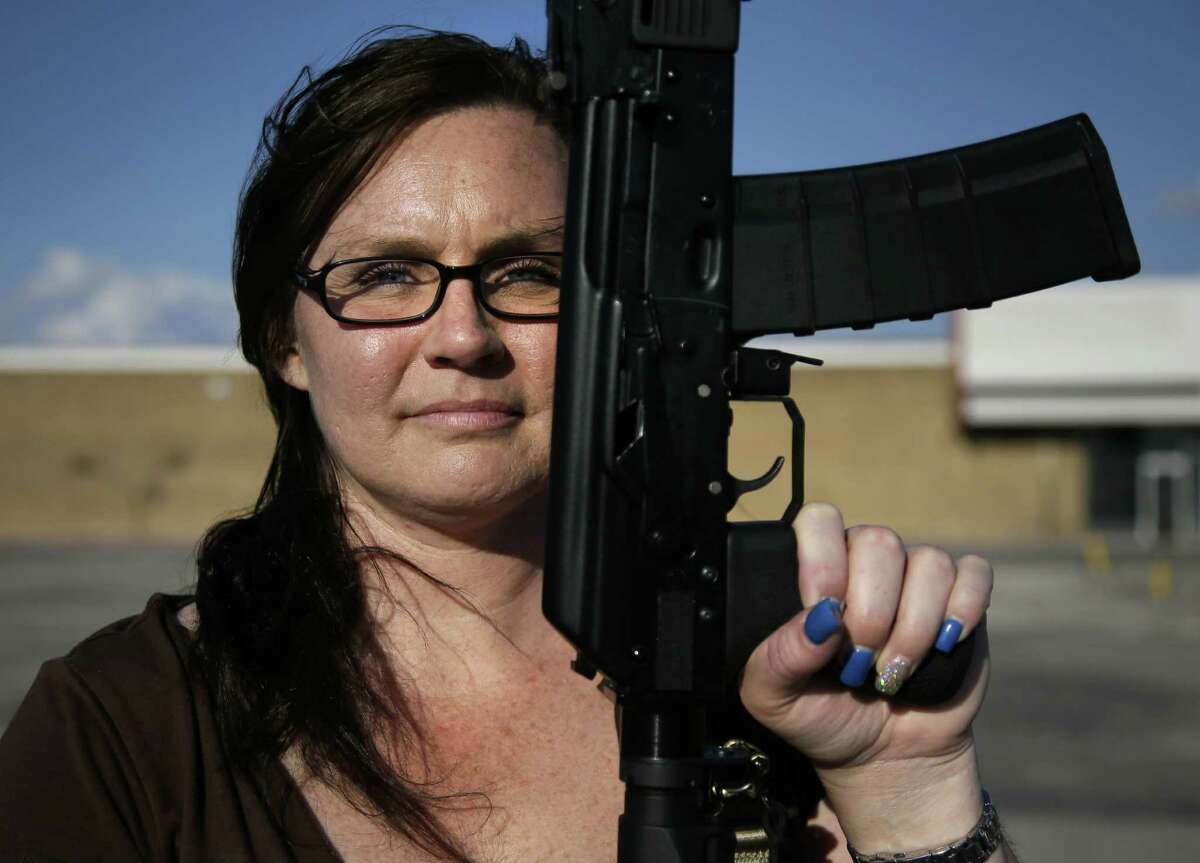 Tara Cowan of Euless, a member of Open Carry Tarrant County, displays a Saiga 556 rifle.