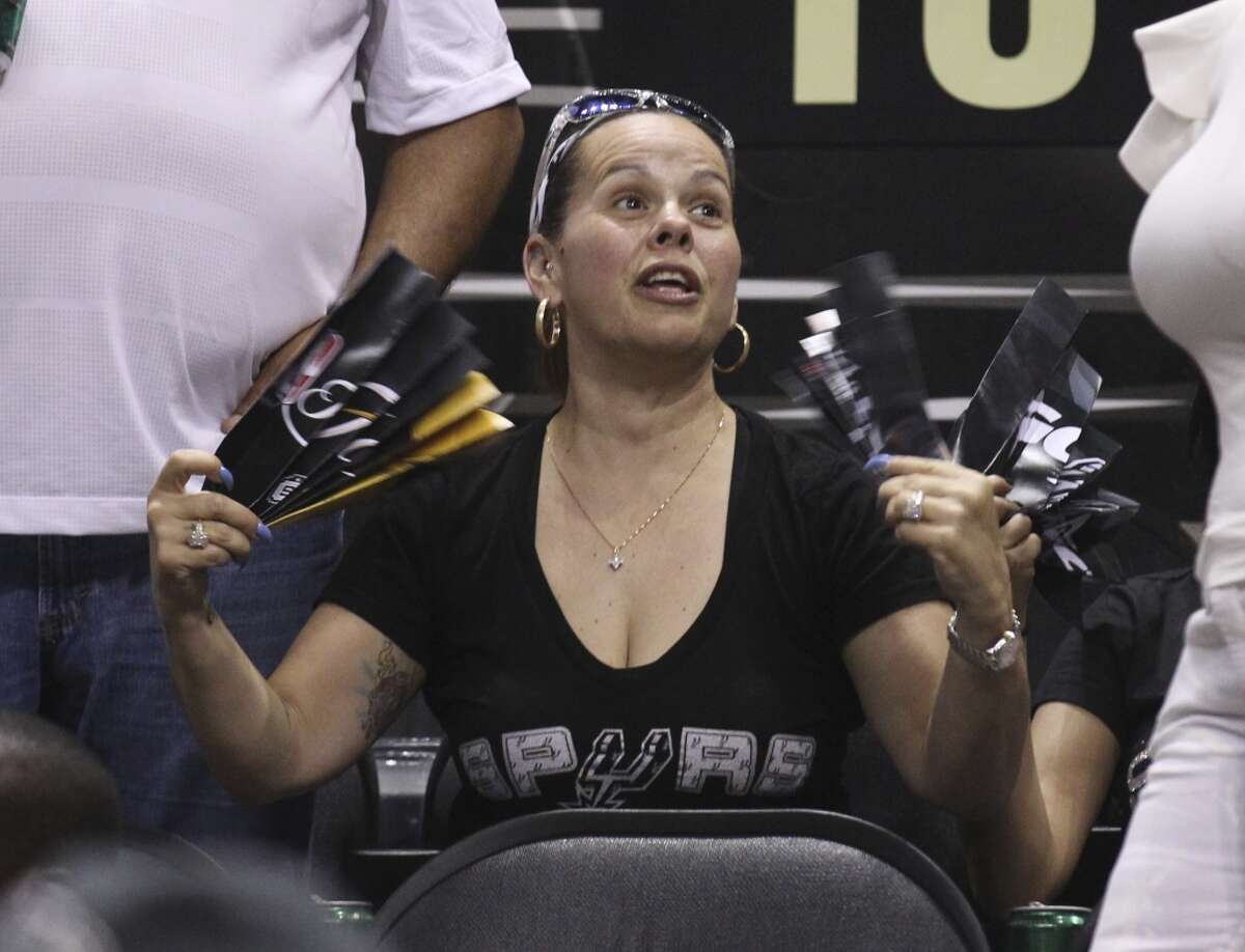 A Spurs fan fans herself after the air conditioning went out in the facility during Game 1 of the 2014 NBA Finals at the AT&T Center on Thursday, June 5, 2014.