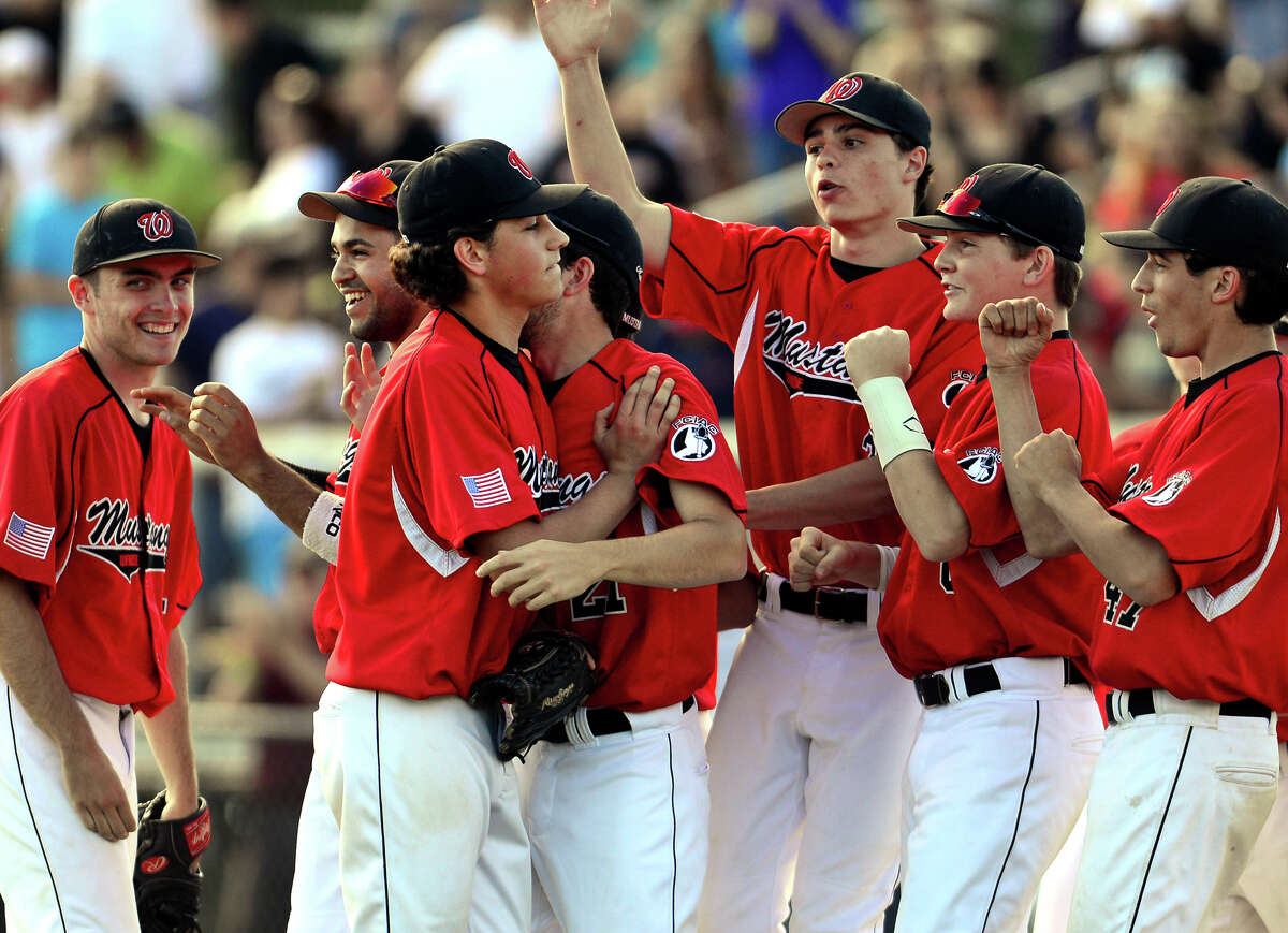 Fairfield Warde pitcher Reese Maniscalco, center left, walks off the field with his teammates celebrating its defeat of Trumbull, during baseball action in Trumbull, Conn. on Friday June 6, 2014.