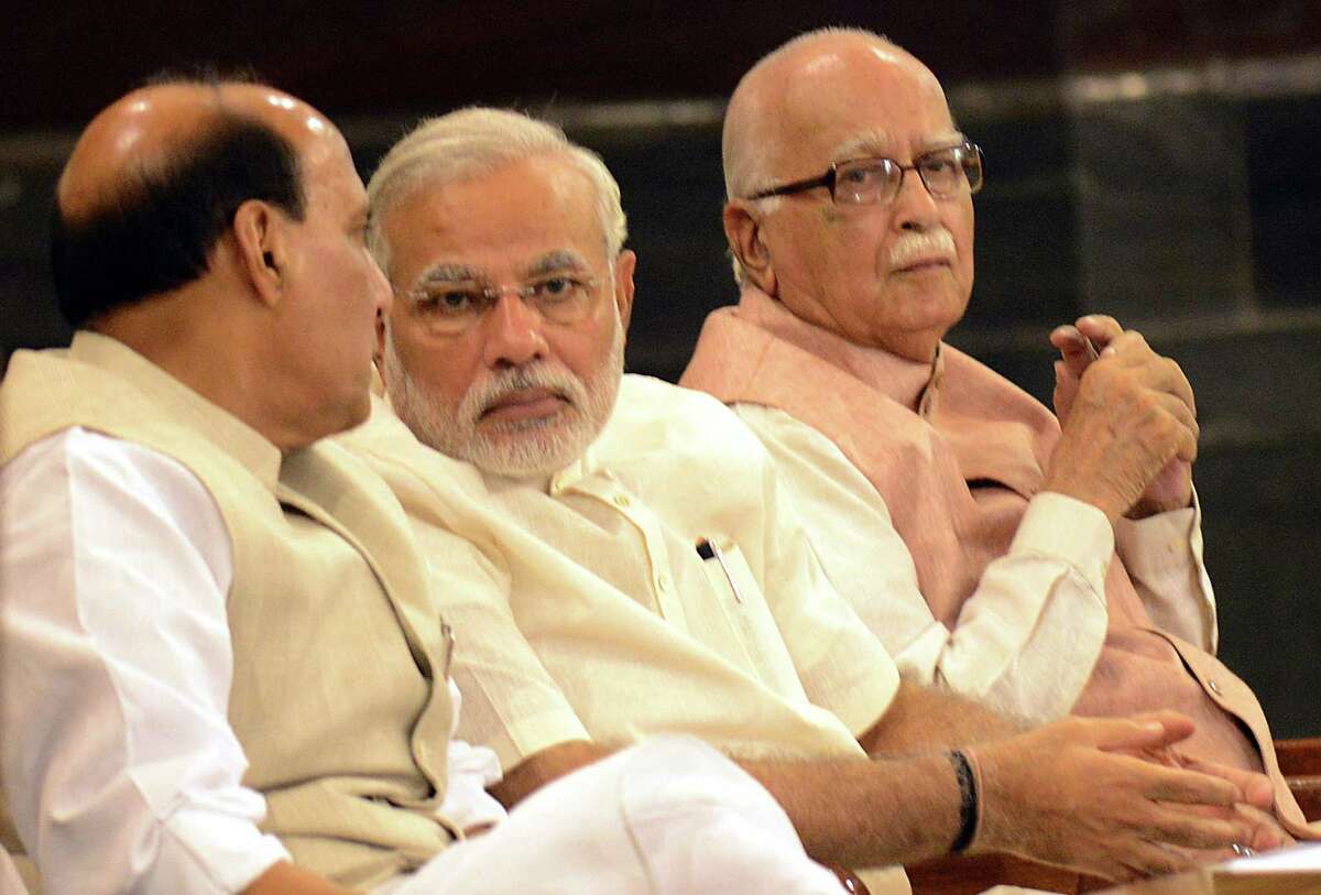 Indian Prime Minister Narendra Modi (C) talks with Bharatiya Janata Party (BJP) President and Indian Minister of Home Affairs Rajnath Singh (L) as senior BJP leader Lal Krishna Advani looks on during the BJP parliamentary party meeting in New Delhi on June 6, 2014. India's new parliament begain its first session after the national election which swept Modi's Bharatiya Janata Party (BJP) to power. AFP PHOTO/RAVEENDRANRAVEENDRAN/AFP/Getty Images