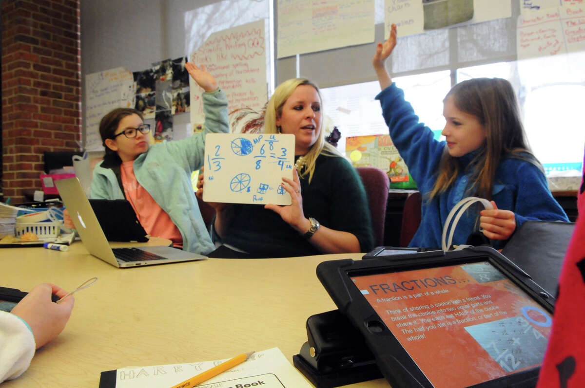 Parkway School fifth-grade teacher Karrie Vale works on a math problem with Riley Geary, right, and Marielle Povinelli during a class earlier this year.