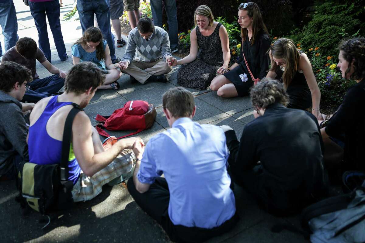 Seattle Pacific University students gather outside of Otto Miller Hall to pray the day after a gunman shot three people on campus, killing one. Many on the campus of the Christian school have turned to prayer and their campus community during the tragedy. Photographed on Friday, June 6, 2014.