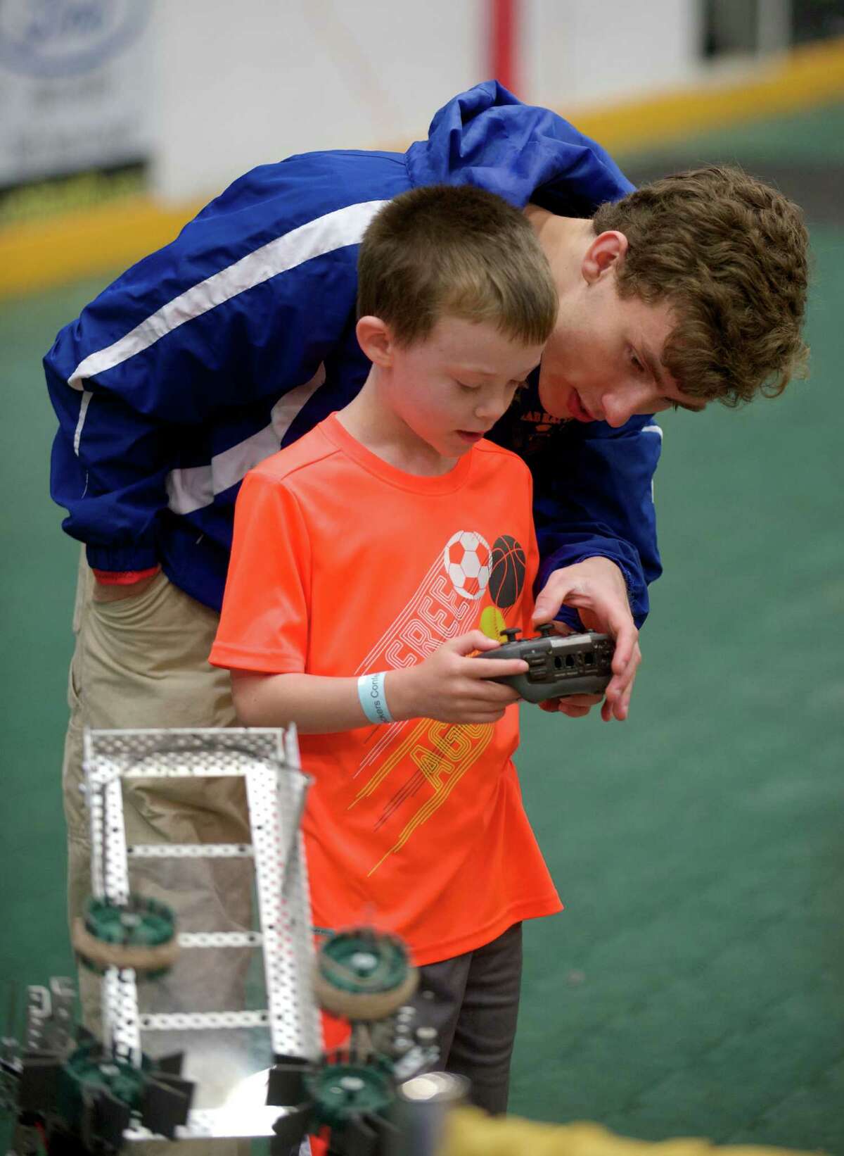 Ben Albano, 17, from Danbury, right, shows Tyler Marshall, 6, of New Fairfield, how to control a robot on display by Team 5150 Mad Hatters, a robotics team from Danbury High School during the 2014 Mad Hackers event, "A Day of Innovation, Technology & Social Media", which took place in Danbury, Conn, on Saturday, June 6, 2014.