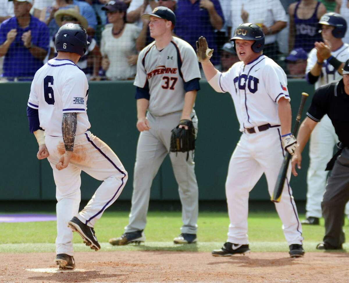 Kyle Bacak, left, and teammate Boomer White are understandably pumped up after Bacak scored on Pepperdine pitcher Corey Miller.