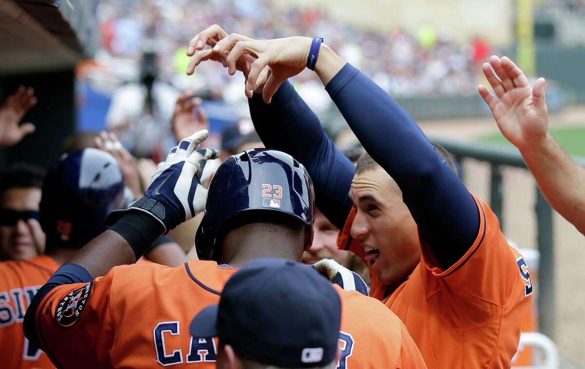 The Astros' George Springer, right, helps Chris Carter enjoy his seventh-inning grand slam, which would be duplicated by Jon Singleton in the ninth. In between, Springer contributed a solo homer in the eighth.