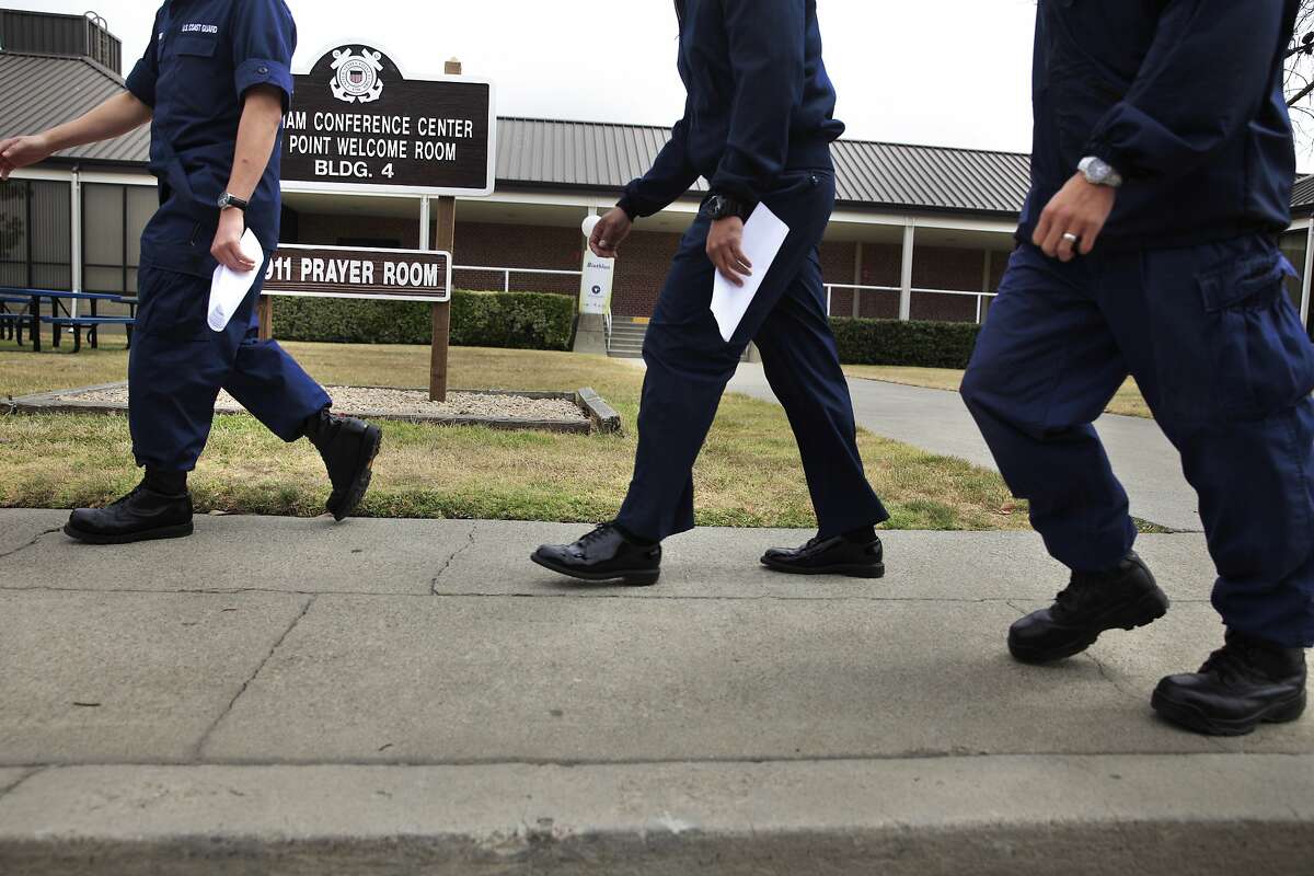 Coast Guardsmen walk past Building 4 on Friday, May 30, 2014 on Coast Guard Island in Alameda, Calif. Petty Officer First Class Christopher Molloy, 31, was sentenced by a military jury panel to 15 years in military prison for crimes he admitted committing from November 2011 to November 2012.
