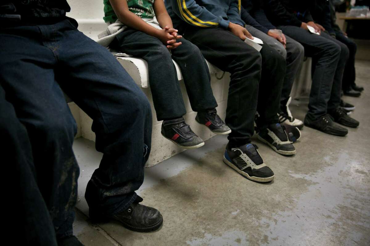 A child from Honduras sits with older youths being processed at a U.S. Border Patrol station in Brownsville. The surge in unaccompanied children crossing the South Texas border illegally has created a humanitarian crisis. The Obama administration has taken steps to help, but more must be done.