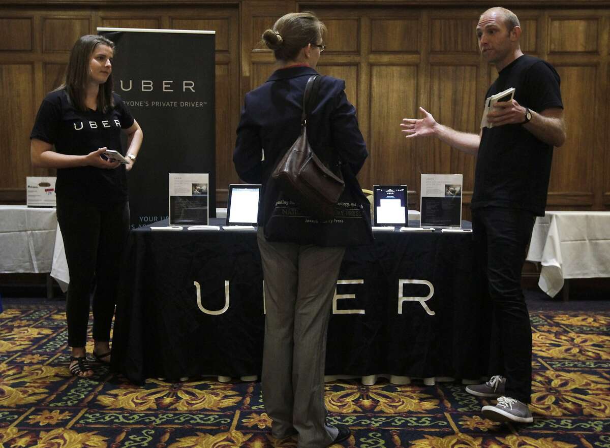 Allison Grant (left) and Spencer Rinkus (right) discuss opportunities at Uber with a job seeker attending a mid-Market job fair in San Francisco, Calif. on Tuesday, June 10, 2014. The popular ridesharing service is seeking as many qualified drivers they can find.