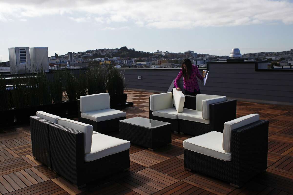 Rachel Turner, the project manager at 1515 15th St., adjusts a cushion on a couch on the building's roof deck while giving a tour for the media on June 11, 2014 in San Francisco, Calif. Fifteen Fifteen is a residential building that has just been completed and is now selling units.