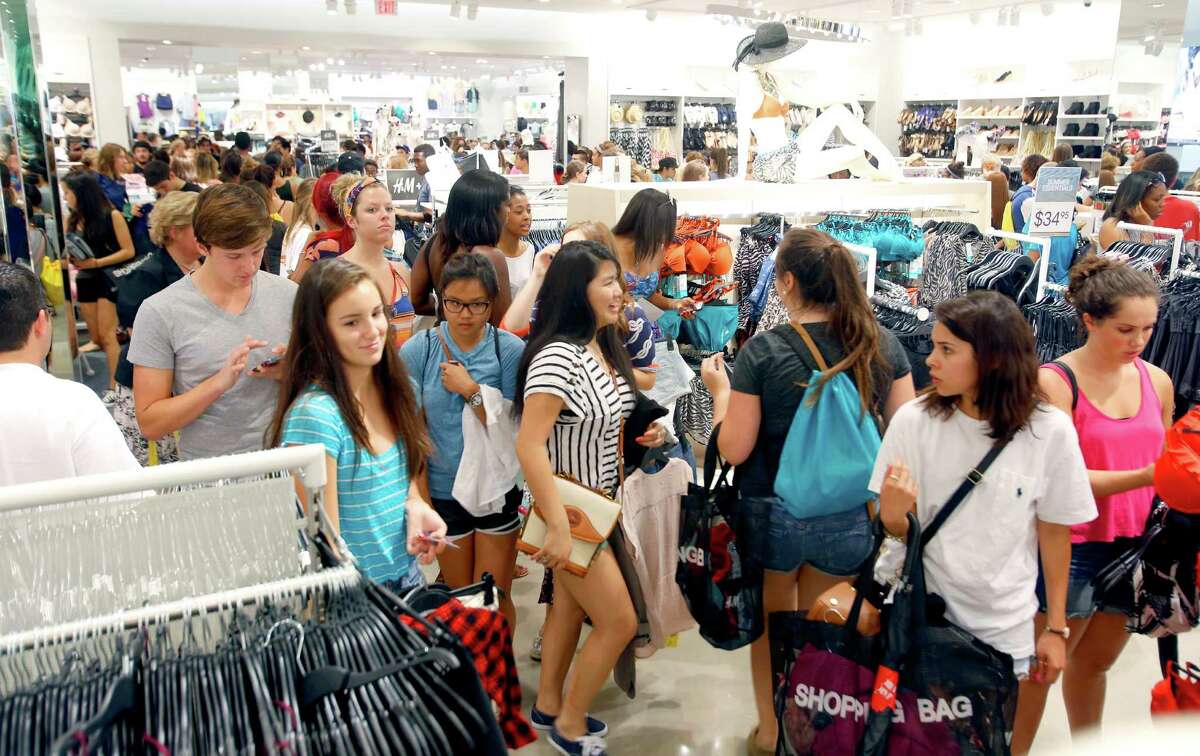 FILE - Some of the over 1,100 people who lined up for H&M clothing store's grand opening Thursday morning June 12, 2014 shop inside the store at the Shops at La Cantera. San Antonio will get a fifth H&M store in October. 