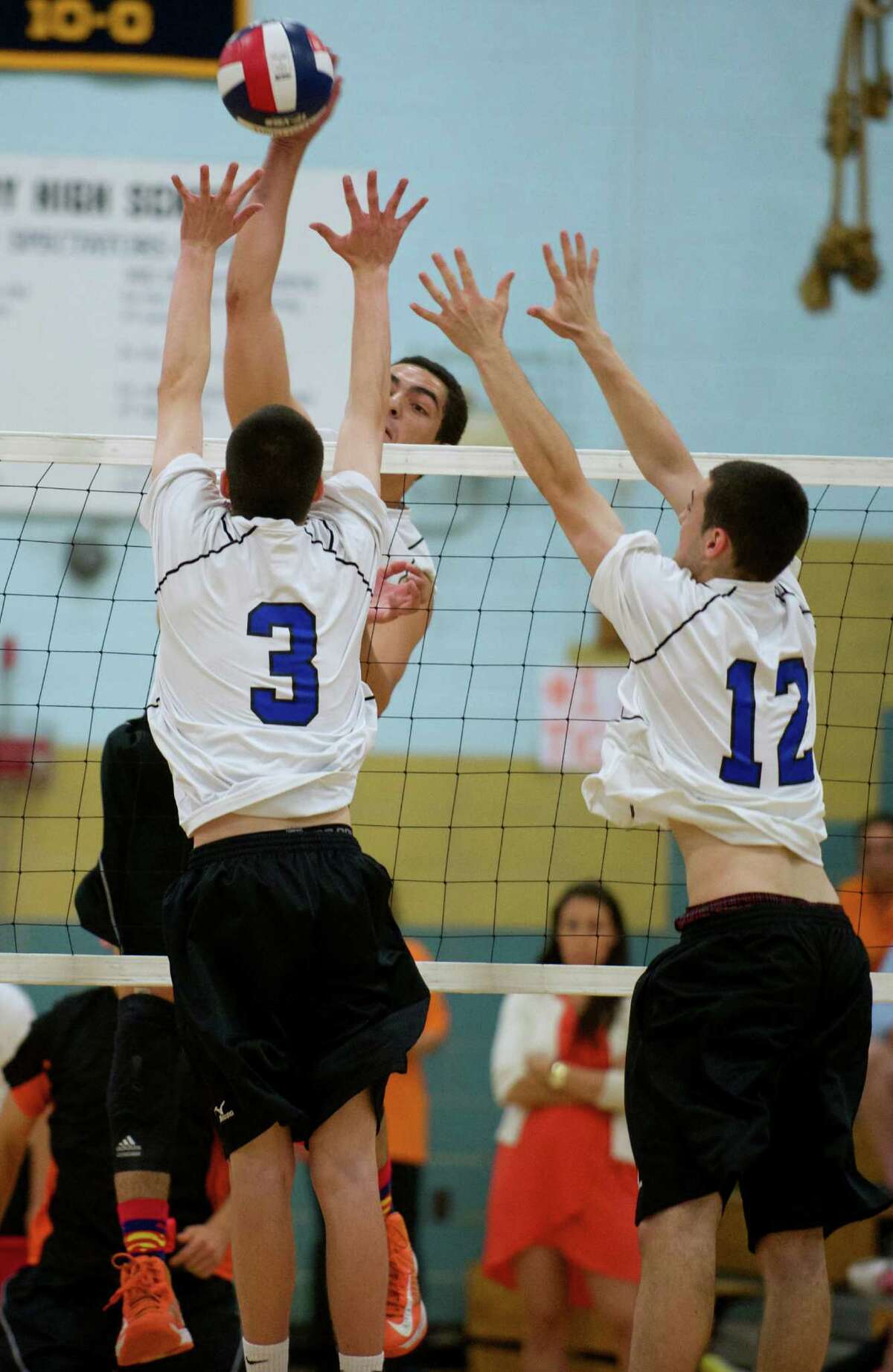Ridgefield's Griffin Jones, #11, spikes the ball over Southington's David Shaughnessy, #3, and Daniel Normandin, #12, during the Class L boys volleyball state championship game between Southington and Ridgefield high schools played at John F. Kennedy High School in Waterbury, Conn, on Thursday, June 12, 2014.