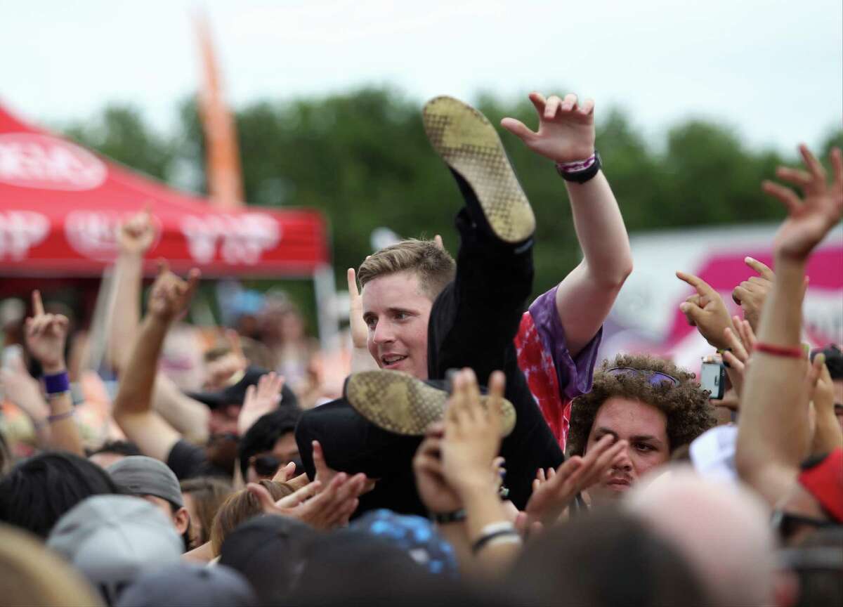 A man crowd surfs on Saturday, June 14, 2014, during the Vans Warped Tour at the AT&T Center parking lot in San Antonio.