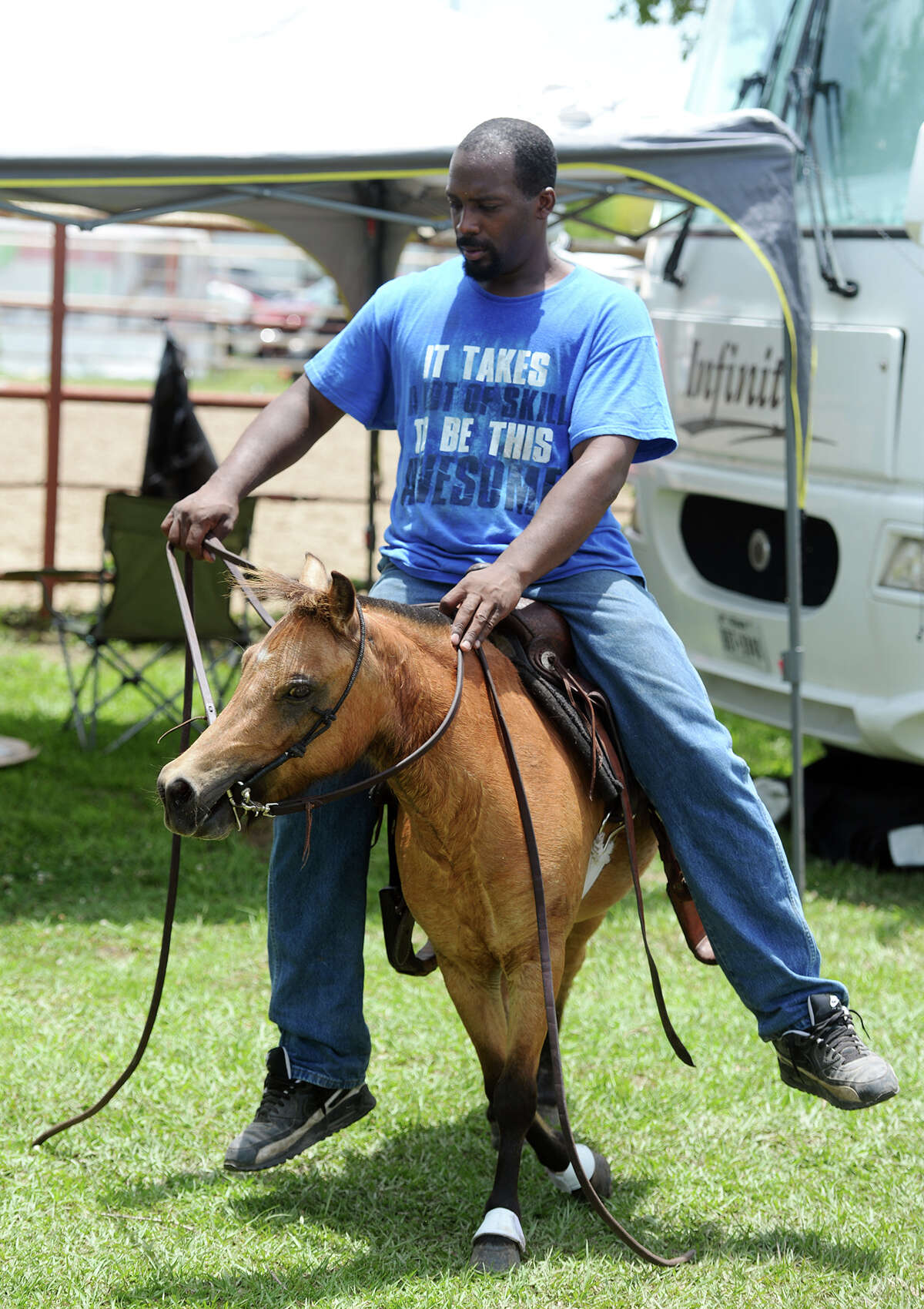 Mario Green helps train up pony Jimmy for a younger rider on Saturday at the Bill Pickett Trail Ride. The Bill Pickett Trail Riders Annual Trail Ride, Zydeco Festival and Rodeo was held at Laday Arena from June 13-15, 2014. Around 200-300 horses took part in Saturday's ride. Photo taken Saturday 6/14/14 Jake Daniels/@JakeD_in_SETX