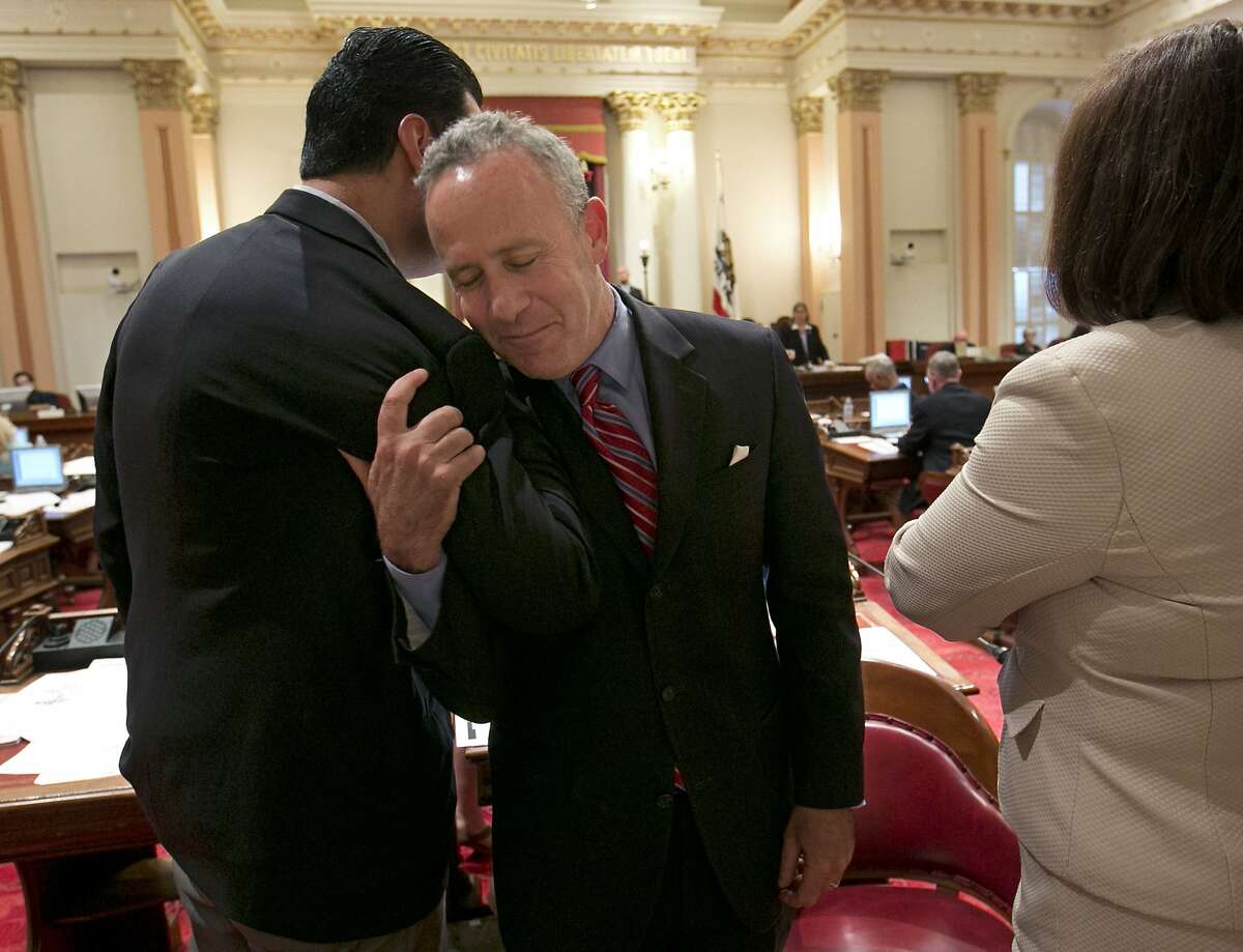 State Senate President Pro Tem Darrell Steinberg, D-Sacramento, center, receives congratulations from Sen. Alex Padilla, D-Los Angeles, as the Senate votes on the state budget at the Capitol in Sacramento, Calif., Sunday, June 15, 2014. Lawmakers faced a Sunday deadline to pass the $108 billion spending plan that meets Gov. Jerry Brown's demand for a rainy day fund and paying down debt while allocating some of the surplus to programs benefiting lower-income Californians. At right is Assembly Speaker Toni Atkins, D-San Diego. This is Steinberg's last budget as he will be leaving the Senate due to term limits.(AP Photo/Rich Pedroncelli)