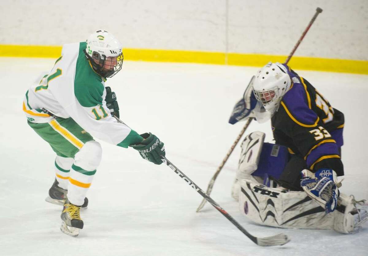 Trinity's CJ DelVaglio, left, slips a goal past Westhill's Wade McManus, right, during an FCIAC boys hockey game at Terry Conners Rink in Stamford, Conn. on Monday, Feb. 15, 2010.