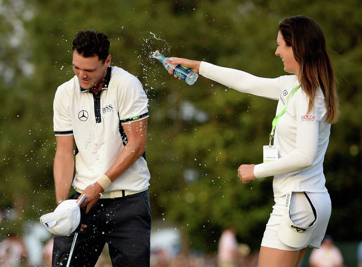 With water substituting for champagne, LPGA player Sandra Gal douses fellow German Martin Kaymer after Kaymer led from start to finish in winning the U.S. Open on Sunday.
