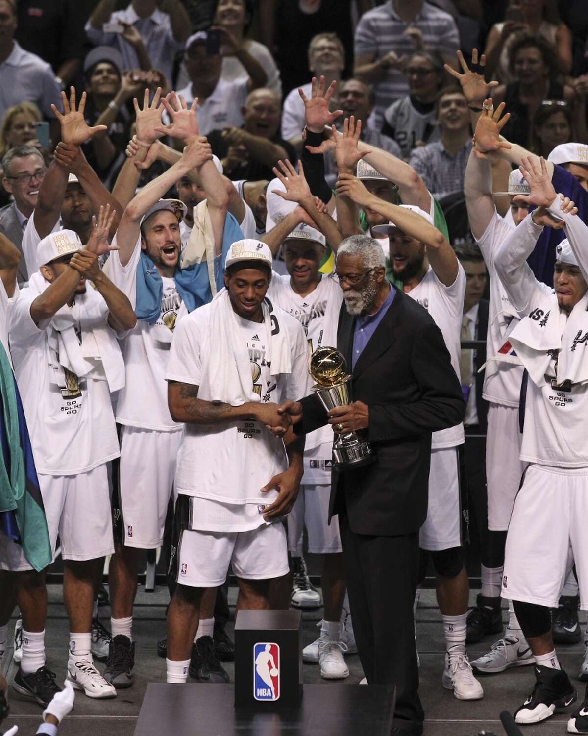 San Antonio Spurs' Kawhi Leonard accepts the Most Valuable Player trophy from NBA legend Bill Russell after the Spurs defeat the Miami Heat in Game 5 of the 2014 NBA Finals at the AT&T Center on Sunday, June 15, 2014. (Kin Man Hui/San Antonio Express-News)