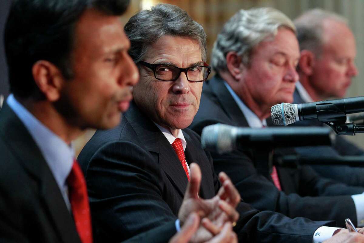 Louisiana Gov. Bobby Jindal, left, meets with Texas Gov. Rick Perry and others June 16, 2014, at the Republican Governors Association media conference held at the Petroleum Club in Houston. Jindal toured the Mexico border area Monday. ( Melissa Phillip / Houston Chronicle )