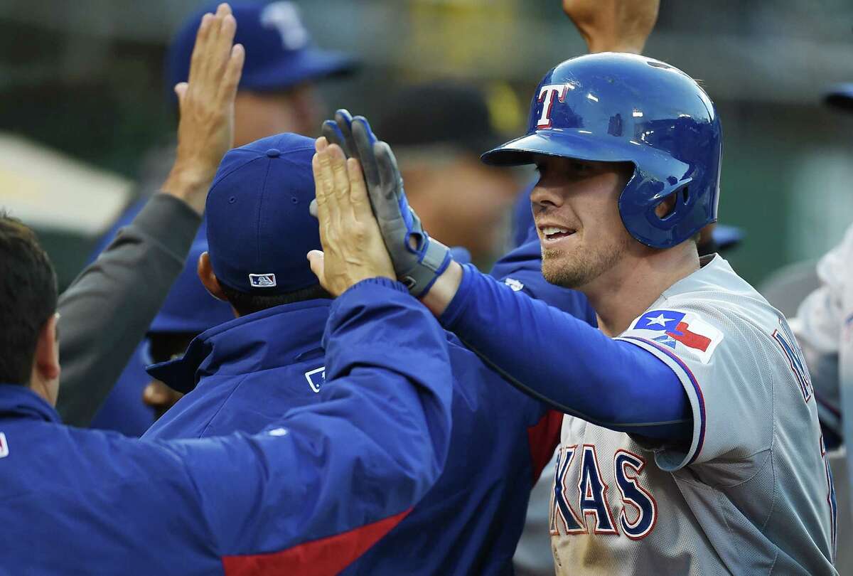 OAKLAND, CA - JUNE 16: Donnie Murphy #16 of the Texas Rangers is congratulated by teammates after hitting a two-run homer in the top of the fourth inning against the Oakland Athletics at O.co Coliseum on June 16, 2014 in Oakland, California.