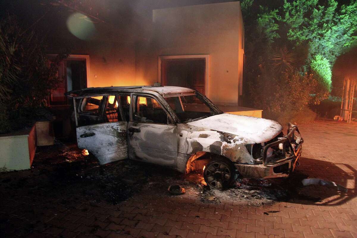 A vehicle and surrounding buildings smolder after they were set on fire inside the US consulate compound in Benghazi late on Tuesday. An armed mob protesting over a film they said offended Islam, attacked the US consulate in Benghazi and killed the US ambassador and three other Americansd. AFP PHOTO (Photo credit should read STR/AFP/GettyImages)