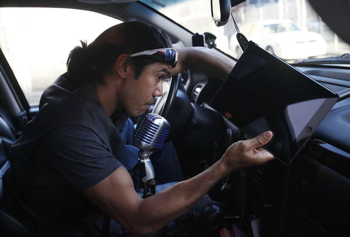 June Cuaresma sets up the iPad in his "Caraoke Lyft" car before setting out to pick up passengers for the evening June 13, 2014 in San Francisco, Calif. Cuaresma decided to create a karaoke experience for his riders simply to enhance the ride. He bought all of the electronics himself. He says it's usually about 50/50 as to whether people want to sing, or not. He records them with a GoPro and puts some of the videos up on YouTube.