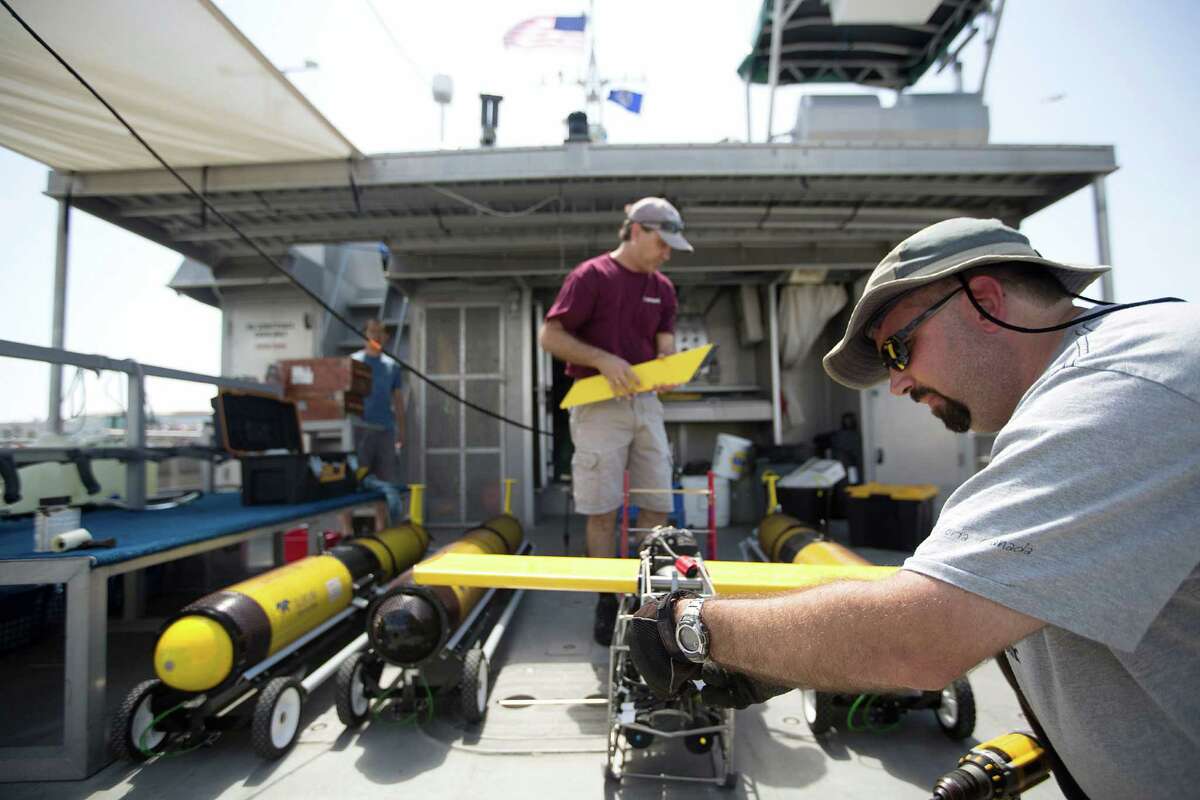 Marine technician Andrew Dancer, right, and Steve DiMarco, a Texas A&M ocean-ography professor, work on an Acrobat towed underwater vehicle