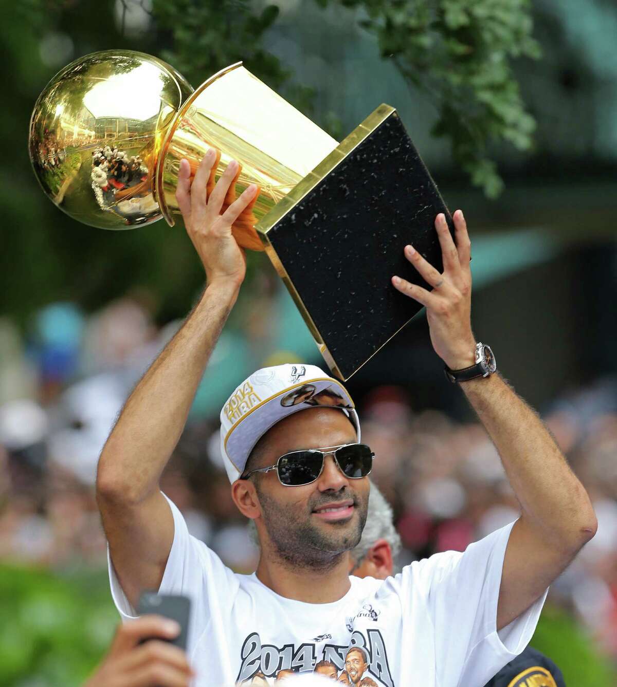 San Antonio Spurs' Tony Parker holds the O'Brien Trophy Wednesday June 18, 2014 during the river parade for the San Antonio Spurs after the team captured their fifth NBA championship.