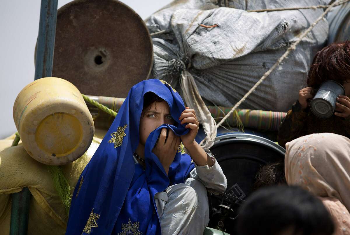 A Pakistani tribal girl sits next to her belongings on a truck after arriving to Bannu, Pakistan, Wednesday, June 18, 2014. Thousands of villagers fled as Pakistani army relax a curfew in troubled North Waziristan. Pakistani jets pounded targets in the country's northwest in major offensives designed to root out safe havens in the volatile region. (AP Photo/B.K. Bangash)