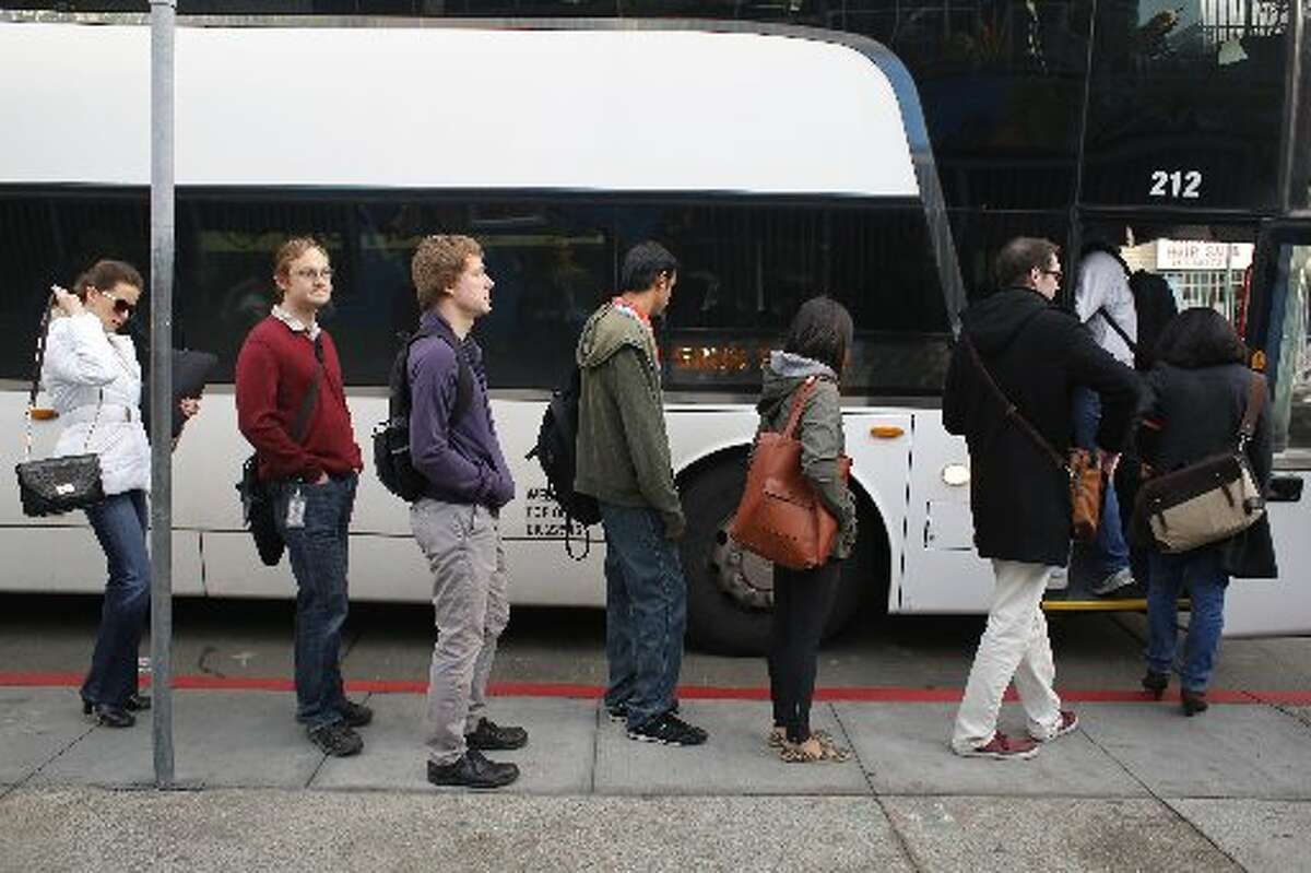 Google employees load up on a Google bus at 24th Street at Valencia Street in April.