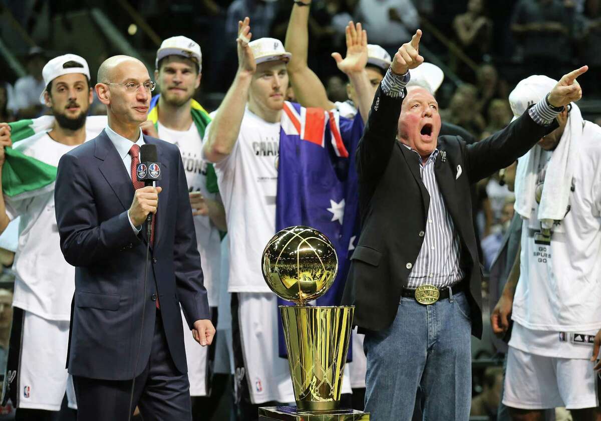National Basketball Association commissioner Adam Silver (left) speaks after Game 5 of the 2014 NBA Finals as San Antonio Spurs owner Peter Holt and the team celebrate after defeating the Miami Heat Sunday June 15, 2014 at the AT&T Center. The Spurs won 104-87.