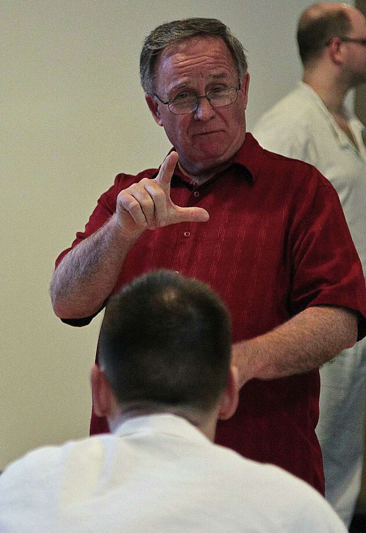 Woodhaven's Rev. Arthur Craig uses sign language with an inmate.