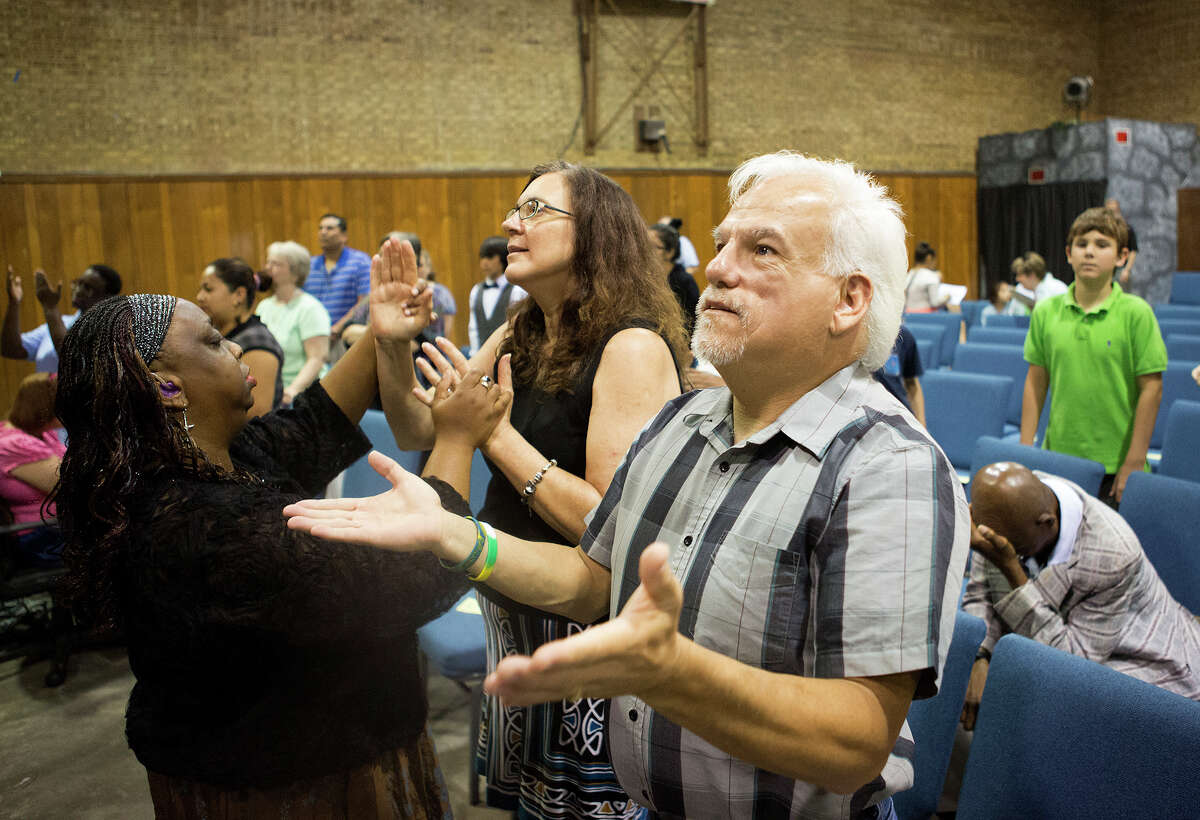 Abel Yarrito and other worshipers sign during a service Sunday at Woodhaven Baptist Deaf Church.