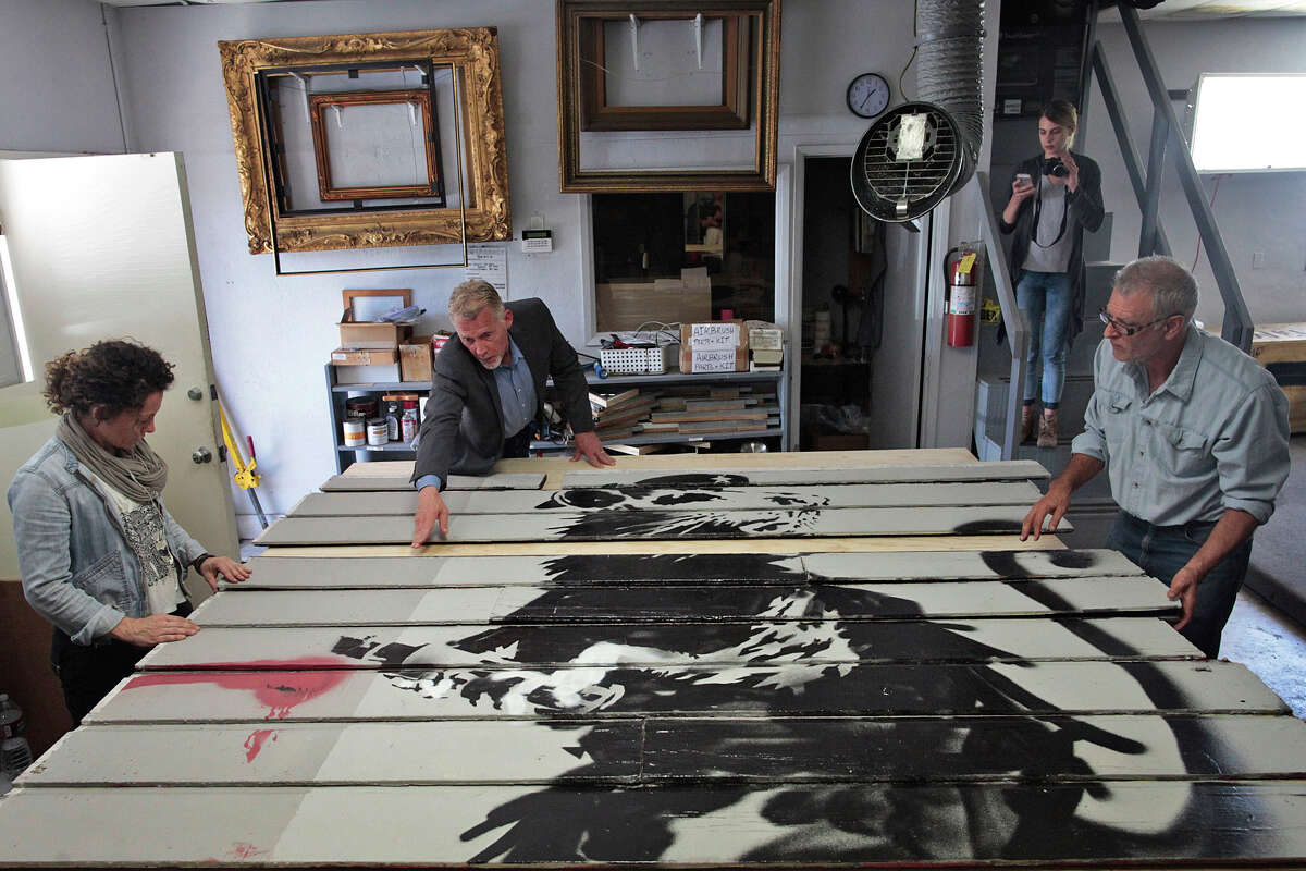 Scott Haskins, second from left, moves slats from a Victorian home featuring a Banksy piece on it in Santa Barbara, Calif. on Tuesday, June 17, 2014. A piece of a Victorian home with Banksy's work on it was taken from San Francisco to Santa Barbara to be framed for display.