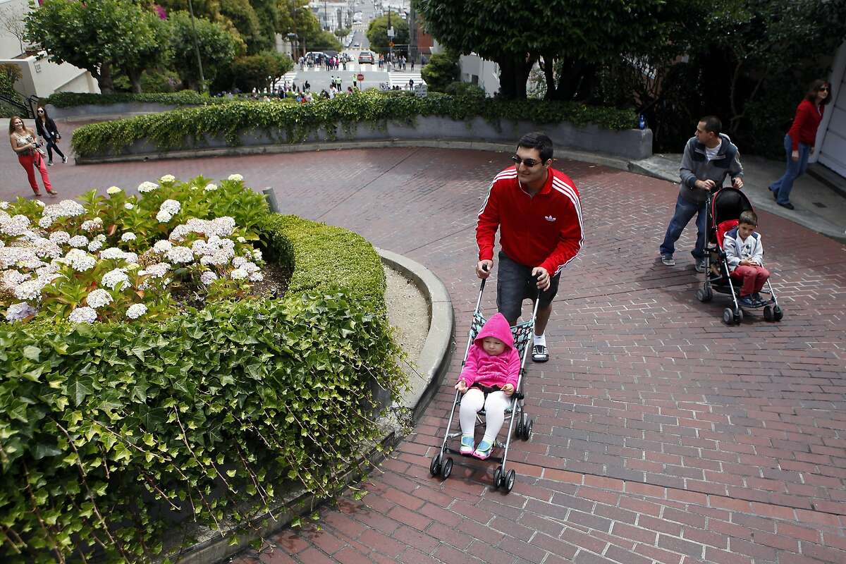 Aram Goul, right, visiting from Oregon, pushes his son Leo Goul(5) as David Petrosyan pushes Aram's daughter Carina Goul(2) up popular Lombard St. after it was closed off to cars as part of a pilot program by the MTA testing weekend closures of the popular tourist destination, in San Francisco, CA, Saturday June 21, 2014.