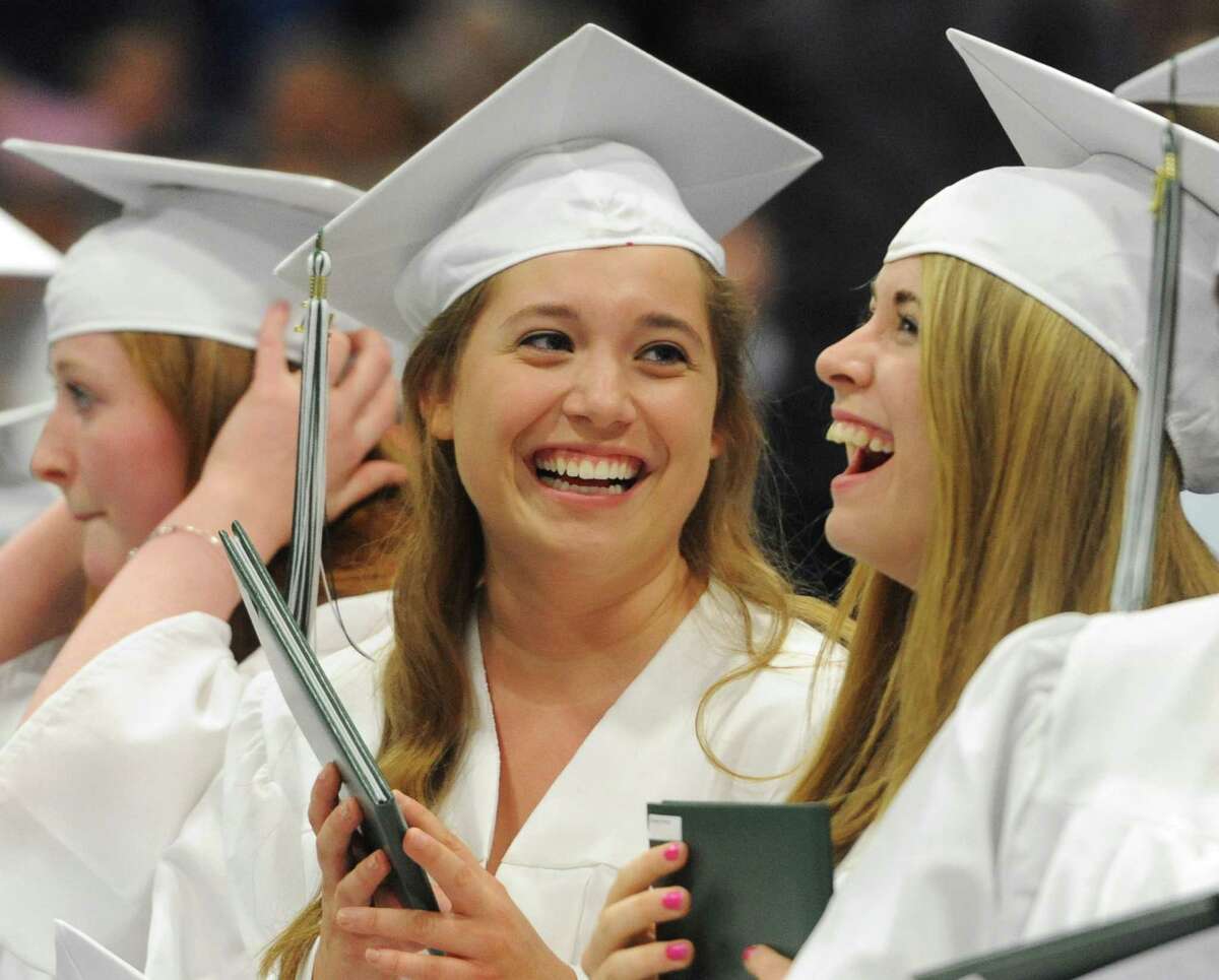 Jamie Teplica, left, and Melanie Talmadge laugh after receiving their diplomas at the New Milford High School 2014 Graduation Ceremony at Western Connecticut State University's O'Neill Center in Danbury, Conn. Saturday, June 21, 2014.