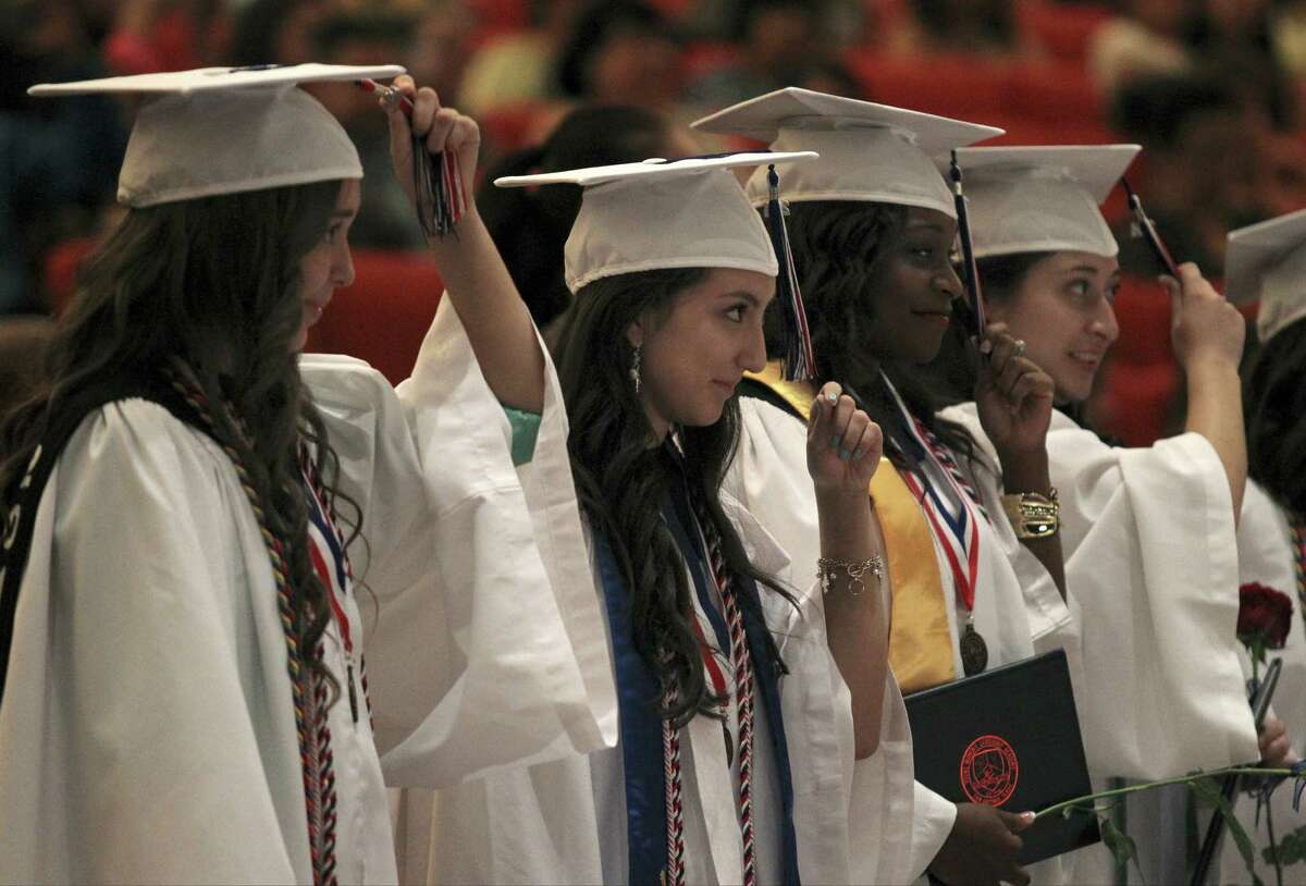 Evelyn Ibarra (desde la izquierda), Gabriela Lara y Thristian Lewis mueven las borlas de sus birretes para indicar sus graduaciones de Young Women's Leadership Academy. La ceremonia se celebra la primera clase graduanda de la Academia.