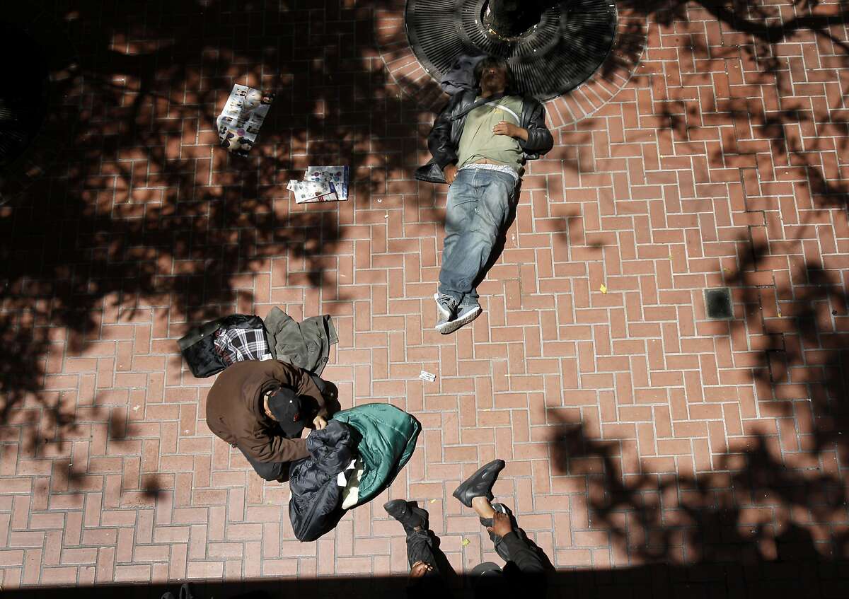 Near the Powell Street BART station, a group of homeless men find some shade in San Francisco, Calif.