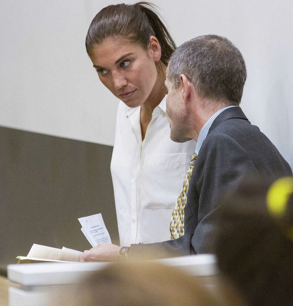 U.S. women's soccer team goalkeeper Hope Solo listens to her attorney Todd Maybrown in Kirkland Municipal Court on Monday, June 23, 2014, in Kirkland, Wash. Solo has entered a not guilty plea following her domestic violence arrest at her sister's home in suburban Seattle.