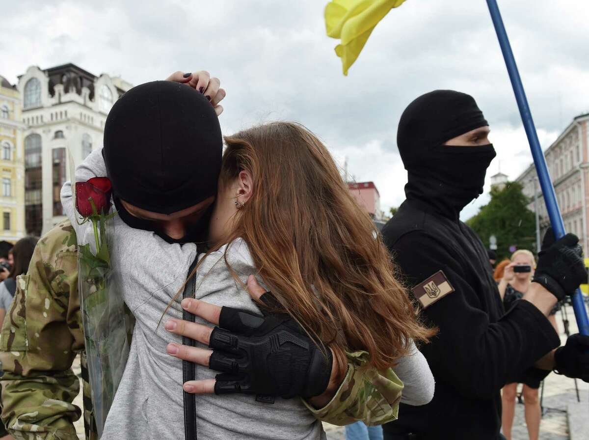 A girl cries as she embraces her boyfriend, a new volunteer recruit of the Ukrainian army 'Azov' battalion heading toward the eastern regions on June 23.