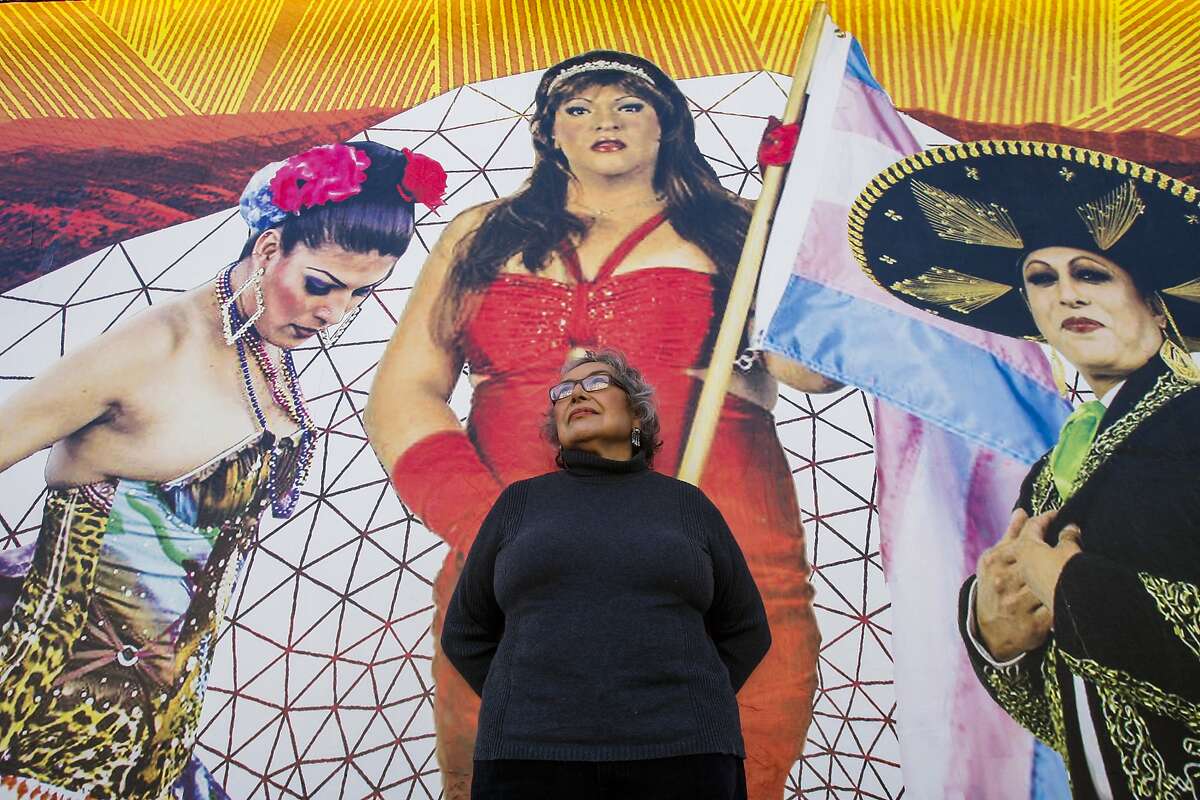 Yolanda López poses below a mural on the side of Galería del la Raza on June 19, 2014 in San Francisco, CA. Yolanda López was evicted from her home and volunteers her time at the gallery.