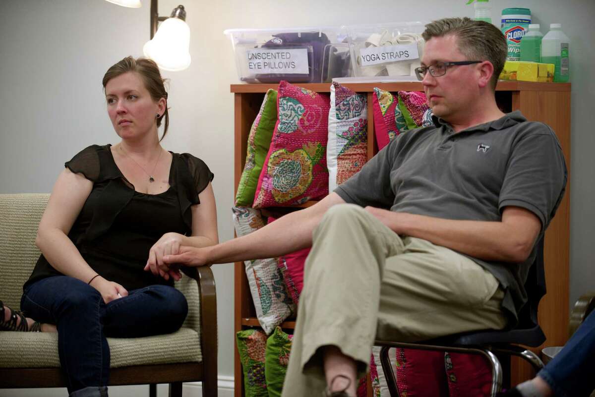 Jamie DelBuono, 30, of Southington, holds the hand of her care giver, Jeremiah Adametz, 42, of Killingworth, during the Young Adult Support Group meeting at Ann's Place, in Danbury, Conn, on Monday, June 23, 2014. The group, which until recently was the only one in the state, meets every month at Ann's Place, which offers support to cancer patients and their families.