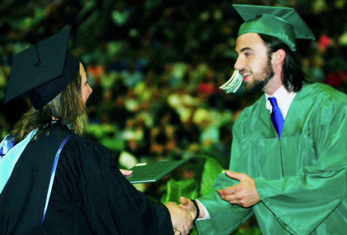 Andrew McGuire happily accepts congratulations and his diploma from Board of Education chairwoman Daniele Shook during New Milord High School's 2014 commencement ceremony at the O'Neill Center on the campus of Western Connecticut State Universityn in Danbury. June 21, 2014