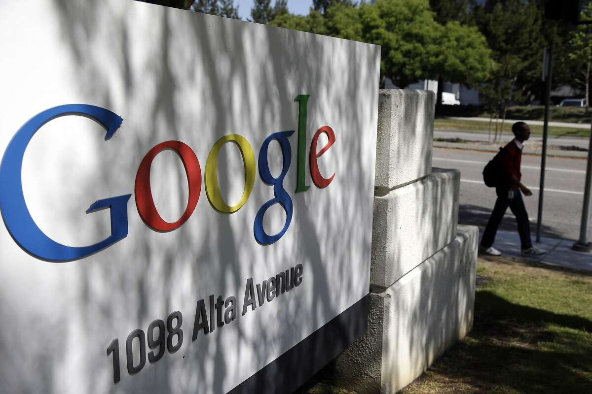 In this June 5, 2014 photo, a man walks past a Google sign at the company's headquarters in Mountain View, Calif. Google is buying Skybox Imaging in a deal that could serve as a launching pad for the Internet company to send its own fleet of satellites to take aerial pictures and provide online access to remote areas of the world. (AP Photo/Marcio Jose Sanchez)