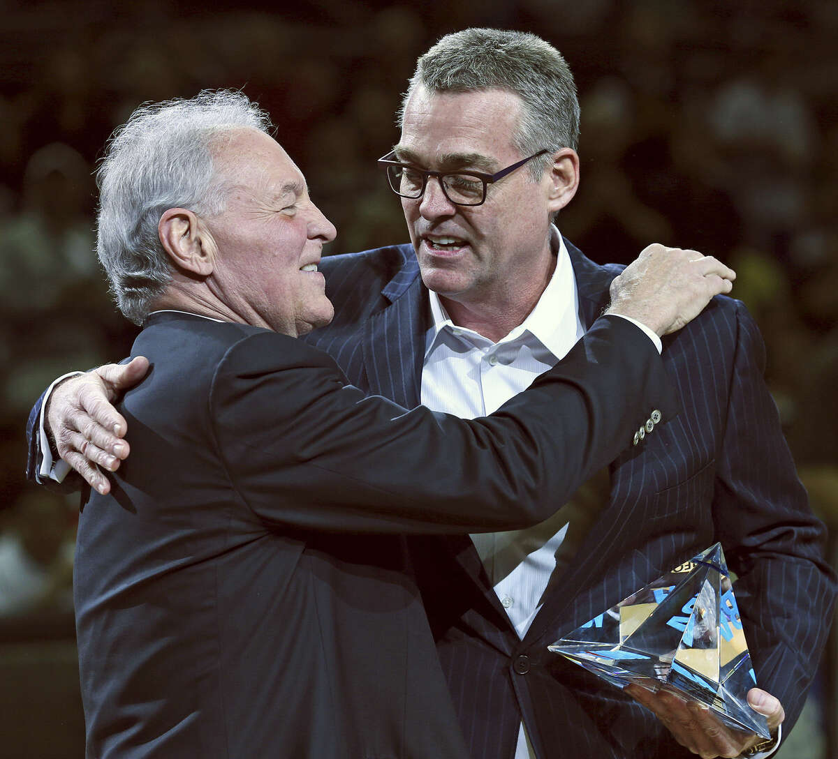 Spurs owner Peter Holt hugs general manager R.C. Buford after giving him his first NBA executive of the year honor before a playoff game against Portland on May 8. Holt and Buford have been the men behind the scenes building the Spurs' dynasty.