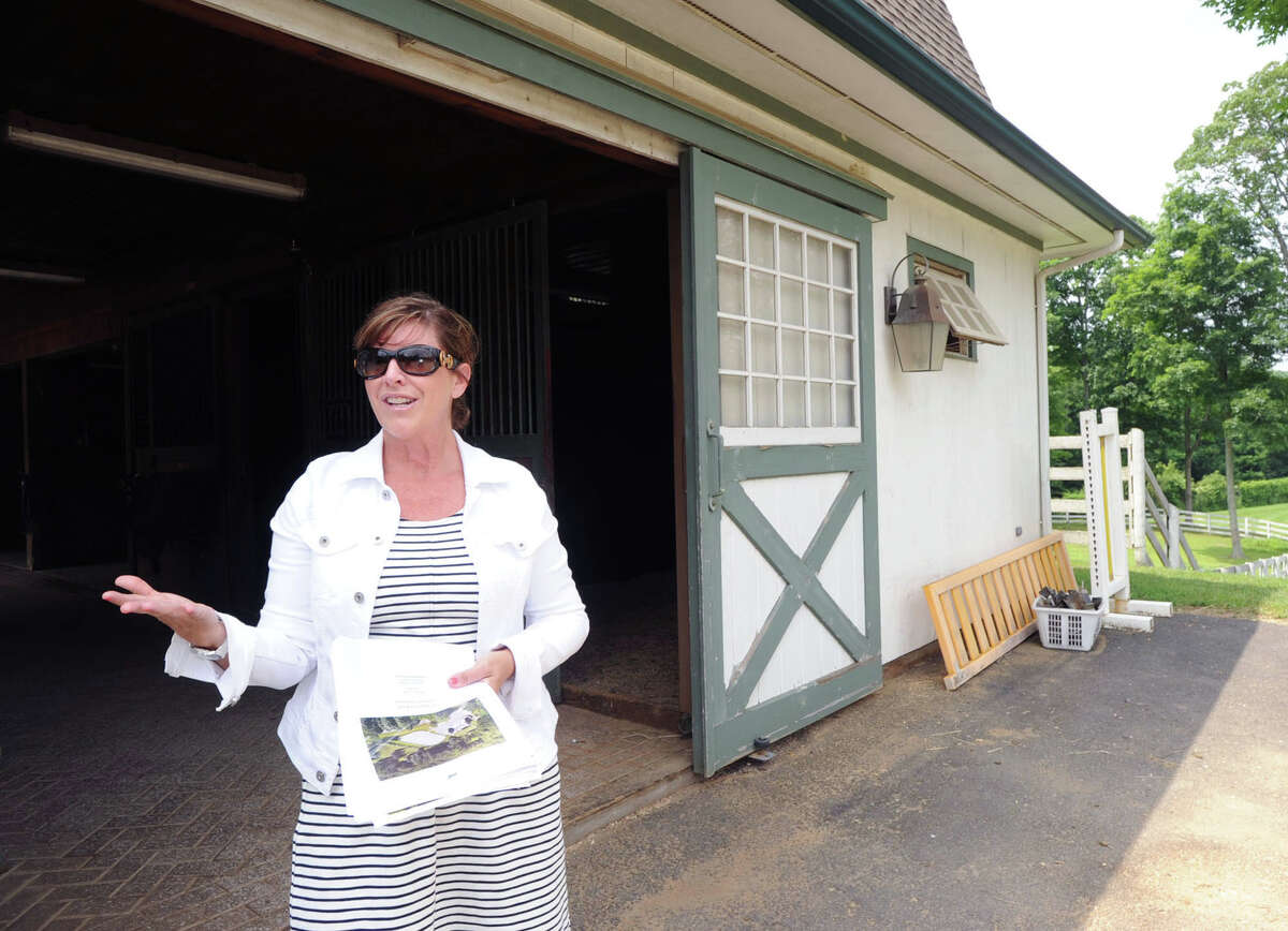Michele Tesei, an agent for Houlihan Lawrence, a real estate company, gives a tour of the main barn on the 25.3 acre property that is for sale with an asking price of $13,900,000 at 50 Lafrentz Rd., Greenwich, Conn., Wednesday, June 25, 2014.