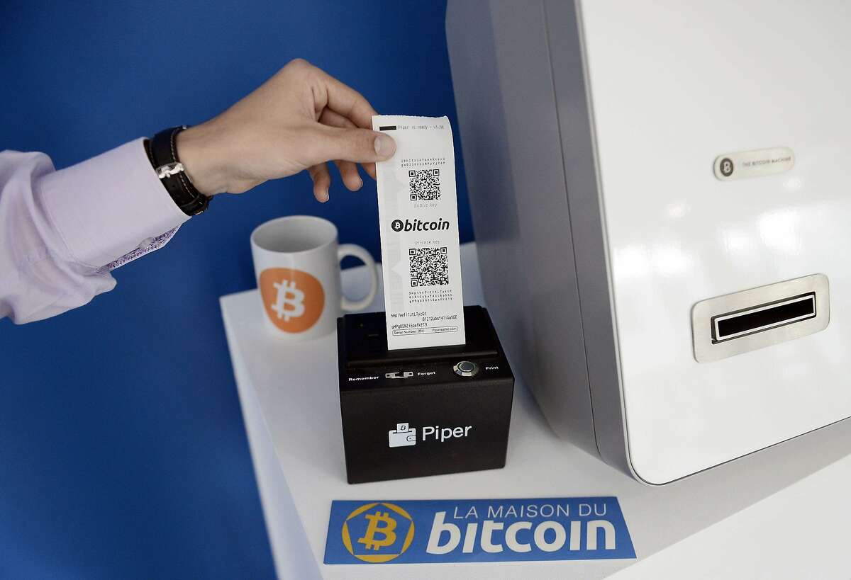 TO GO WITH AFP STORY BY SEVERINE ROUBY This picture taken on June 20, 2014, shows a man taking a receipt from a Bitcoins (virtual currency) dispenser at La Maison du Bitcoin in Paris. Since the month of May, Bitcoin, a virtual currency which has become popular as a means of paying goods and services on the internet, now has headquarters in Paris at "La Maison du Bitcoin" where the currency will be promoted and a dispenser and changing counter will be available to the general public. AFP PHOTO / STEPHANE DE SAKUTINSTEPHANE DE SAKUTIN/AFP/Getty Images