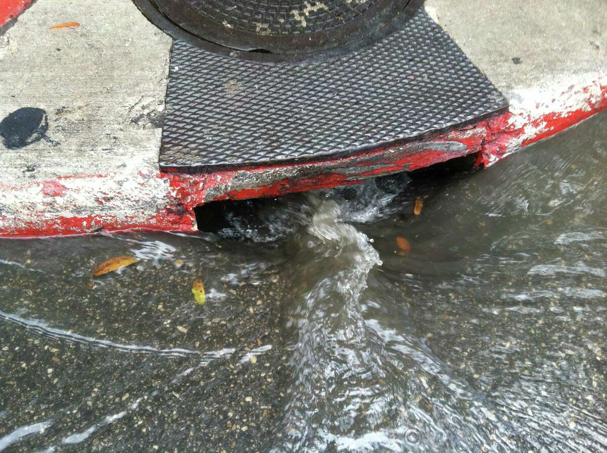 Water rushes into a storm drain at Alamo and 4th streets after storms blew through the San Antonio area late Thursday morning, June 26, 2014.